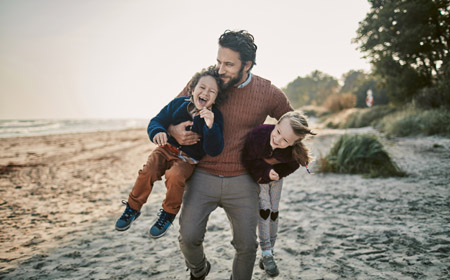 man with children on the beach